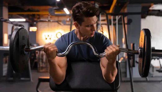 Homme dans une salle de sport en train d'effectuer un mouvement de curl biceps à la barre