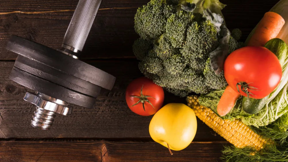 Fruits et légumes sur une table en bois avec la vue du ciel à coté d'un haltère de musculation